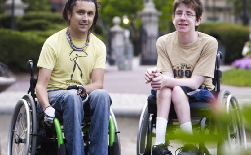 A mentor and mentee in wheelchairs enjoy an afternoon in the park together