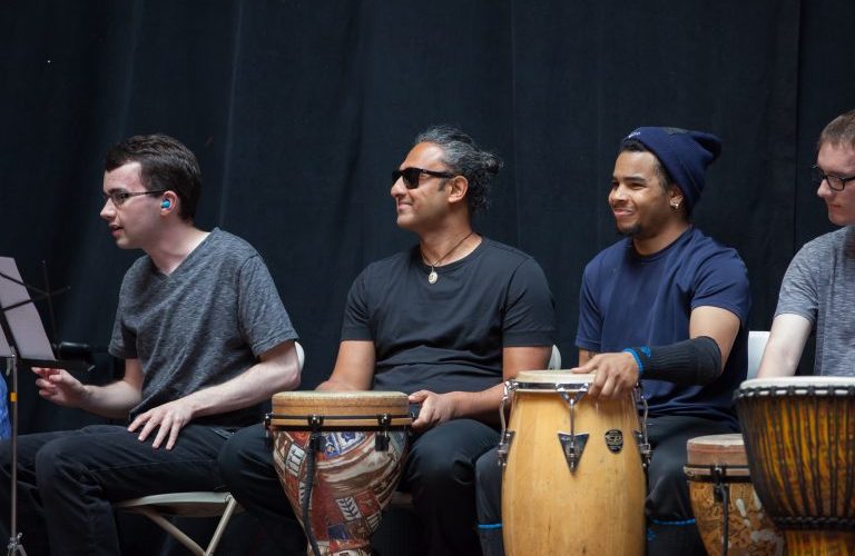 Deep sitting in front of a drum, smiling